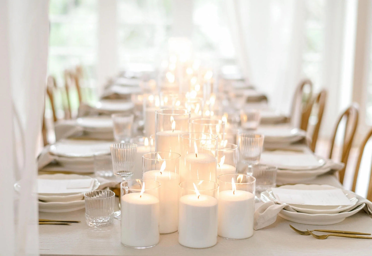 Assorted taper and pillar candles on mirrored bases—candle rentals to create a warm, romantic atmosphere at weddings and special events.