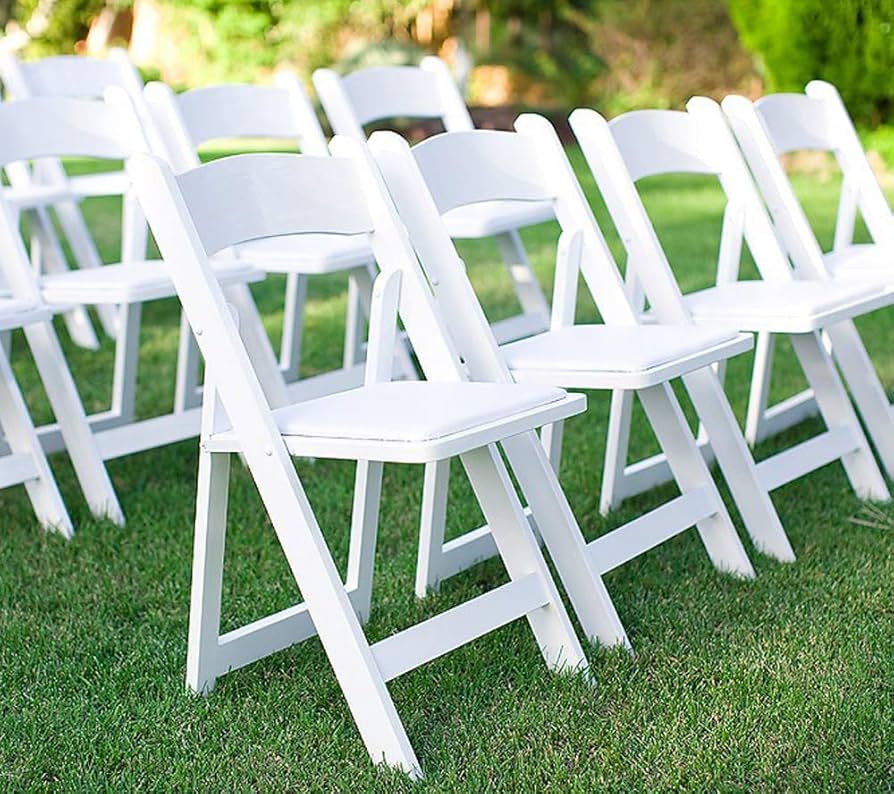 White folding chairs on a manicured lawn for outdoor weddings—seating rentals perfect for event planners and party rental services.